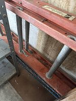 Close view of fiberglass ladder rungs and frame showing dirt and wear.