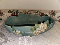 Close-up of bowl side showing white flowers, leaves in relief, minor chips on rim.