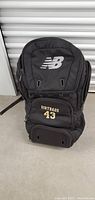 Front view of black New Balance backpack with large NB logo and Dirtbags 43 embroidery