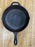 Top view of the seasoned cooking surface of the Lodge cast iron skillet, showing signs of use and wear.