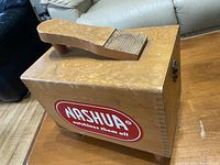 Photo showing the top of the wooden shoe polishing box with attached wooden brush and large Nashua sticker.