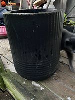 Exterior view of black Mayne self-watering flower pot showing textured ridges and cylindrical shape