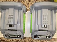 Top-down view showing two ECO battery chargers side by side, each with visible battery slots and charging indicator panels.