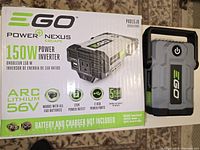 Box showing EGO Power Nexus Escape 150W Power Inverter product details including ARC Lithium 56V, compatibility with EGO batteries, 120V outlet, 2 USB ports, and 5-year warranty.