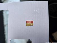 Close up photo of SanDisk 128GB micro SDXC Extreme memory card on a white surface.