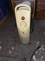 Front view of beige Airworks oil-based heater with power cord on floor.