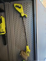 Full view of Ryobi cordless edger showing long shaft, handle, and cutting head.