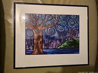 Photo of the framed watercolor painting showing the tree motif with spiral patterns in the sky, including ceiling light reflection.