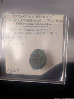 Front of bronze coin in 2x2 flip with handwritten label describing Byzantine Empire Maurice Tiberius 582-602 AD pentanummium coin