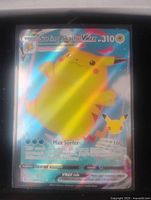 Front view of Surfing Pikachu VMAX full art holo Pokemon card showing artwork and card details with holographic shine and slight light glare.