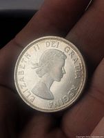 Obverse side of the 1964 Canadian silver dollar coin showing Queen Elizabeth II profile.
