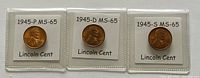 Obverse sides of the three 1945 Lincoln Wheat cents with mint marks P, D, and S, graded MS-65, each in protective holders.
