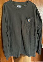 Front view of the Carhartt long sleeve grey tee shirt hanging showing full shirt and pocket