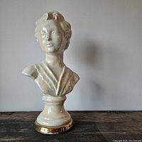 Front view of pearly ceramic bust showing facial features and glossy finish