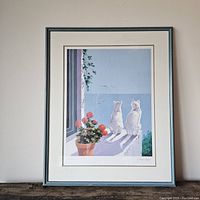 Full view of framed watercolour painting showing two cats, flowers, and ocean scene in blue wooden frame.