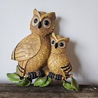Front view of the owl wall hanging showing both large and small owl on green leaves.
