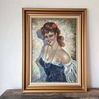 Full view of the vintage oil painting portrait in its frame, showing a smiling woman in an evening gown with a red flower in her hair.
