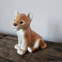 Front and side view of the lion cub figurine showing detailed face and body.