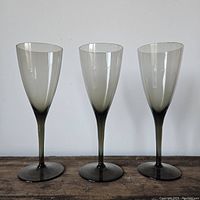 Photo of three vintage smoked grey wine glasses standing side by side showing their shape and color gradient.