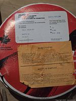 Close up of a large spool showing label with product details: 100% Nylon, 18 mm width, 25 meters original length, white color, brand Velcro