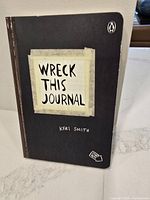 Cover of "Wreck This Journal" by Keri Smith with black cover and title