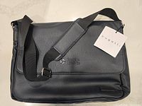 Front view of the blue marine vegan leather laptop briefcase with adjustable shoulder strap and Bugatti tag visible on flap.
