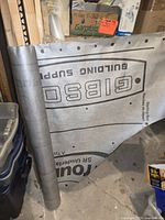 Partial roll of gray Gibson roofing underlayment with visible branding and markings.