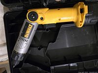 Yellow and silver DeWalt power screwdriver positioned in open black carrying case, showing adjustable angled head and chuck.