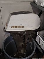 Front view of the Viking 6HP outboard motor placed inside a tub for display or storage, showing the white top cover and brown base.