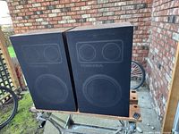 Pair of vintage Toshiba speakers front view showing the fabric grill with Toshiba branding and speaker outlines.