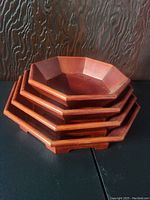 Stacked set of four octagonal wooden nesting trays in dark brown finish.