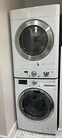 Stacked washer and dryer units in alcove