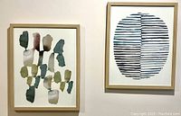 Two framed watercolor prints side by side, hanging on a wall, showing abstract art in blues and olives with birch wood frames