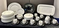 Full set of Rosenthal dinnerware including plates, platters, cups, and bowls in white and black porcelain.
