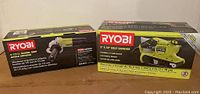 Two Ryobi power tool boxes side by side: left is 4-1/2 inch barrel grip angle grinder, right is 3x18 inch belt sander