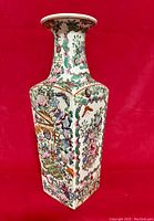 Photo of one side of the Famille Verte porcelain vase showing detailed floral and butterfly decorations with bright enamel colors.