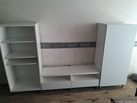 Full view of the three piece set showing two tall shelving units on either side of the low TV stand unit.