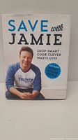 Front cover of 'Save with Jamie' cookbook by Jamie Oliver showing the title, subtitle, and image of Jamie Oliver.
