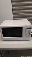 Front view of the white Panasonic microwave, showing door and general shape