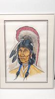 Framed portrait painting of Native American man with feathered red and white headdress by Terry Greene.