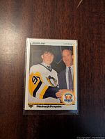 Front of 1990-91 Upper Deck Jaromir Jagr rookie card showing player in Penguins jersey and holding draft puck.