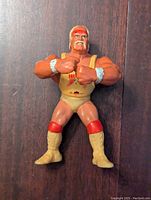 Front view of Hulk Hogan WWE action figure showing yellow wrestling singlet with red details and muscular build.