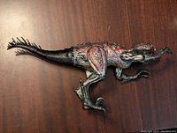 Side view of the Jurassic World Scorpius Rex dinosaur figure showing the detailed body and tail.