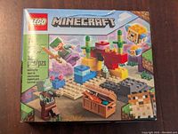 Front view of Lego Minecraft 21164 The Coral Reef set box showing the product name, number of pieces, and graphic of the kit with characters and coral elements.