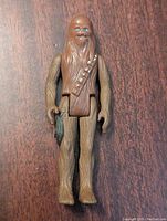 Front view of 1979 Kenner Star Wars Chewbacca action figure standing upright on a wooden surface, showing detailed fur texture and blue eyes.
