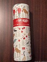Cylindrical container of True North water bottle in decorative packaging with Canadian themed illustrations shown from front view.