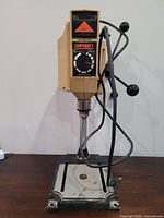 Front view of the beige ShopCraft drill press on metal base showing the control panel and chuck.