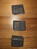 Top view of three miniature Bibles showing gold embossed dove and rays of light design on black covers.