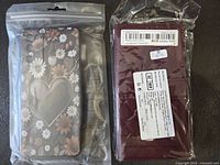 Two brand new Samsung Galaxy S20 FE phone cases in sealed plastic packaging, one floral design and one solid burgundy.