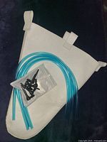 Image shows white tree tapping bag, blue plastic tubing, and black plastic spouts on a black background.
